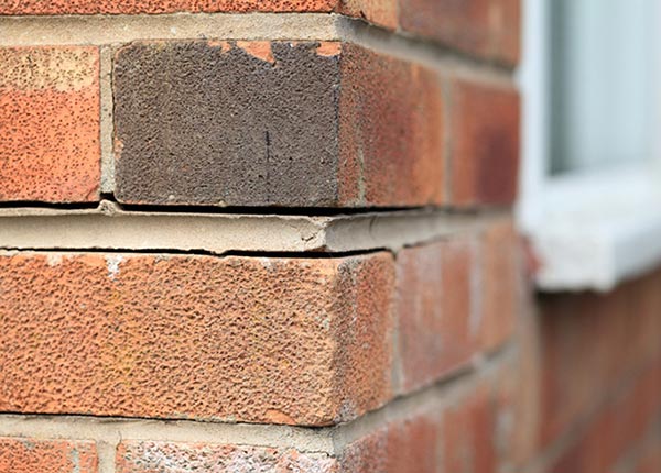 Exterior brick foundation where the bricks have gaps between them