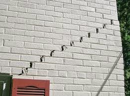 A stairstep crack forming upwards to the top of the exterior foundation