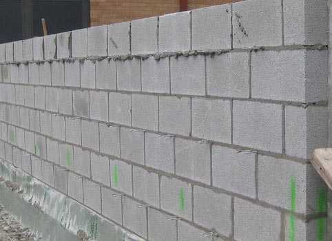 A concrete masonry unit wall stable and flush